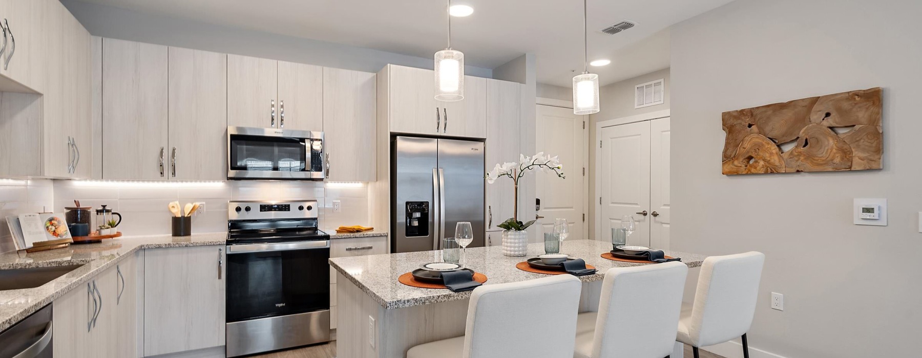 a kitchen and island with chairs