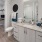 a bathroom with a large mirror a sink a toilet and closet access