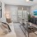 a living room with a tv and a couch and balcony door