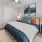a bedroom with a large bed and a fan